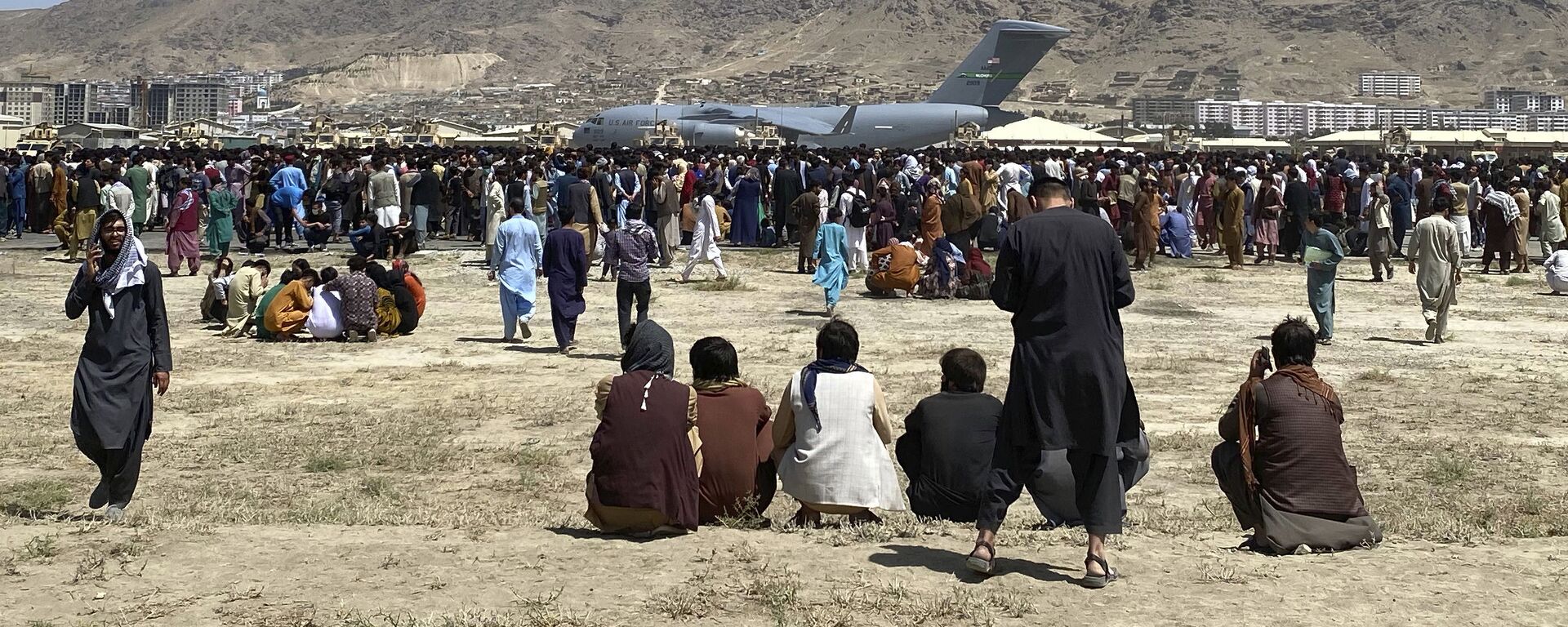 Centenas de pessoas se reúnem perto de um avião de transporte C-17 da Força Aérea dos EUA em um perímetro no aeroporto internacional de Cabul, Afeganistão, 16 de agosto de 2021 - Sputnik Brasil, 1920, 31.08.2022