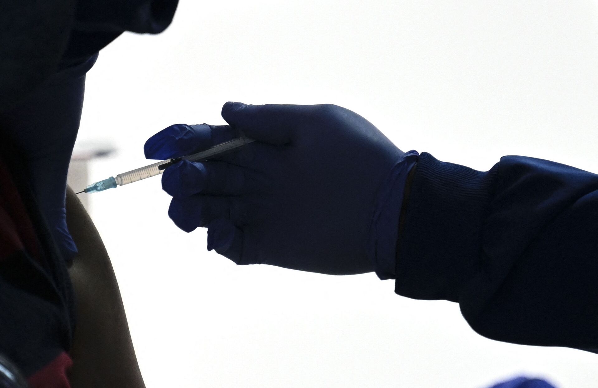 Trabalhador da área da saúde inocula um homem com uma dose da vacina CoronaVac contra a COVID-19 no Aeroporto Internacional de Bogotá, Colômbia, 16 de julho de 2021 - Sputnik Brasil, 1920, 28.05.2022