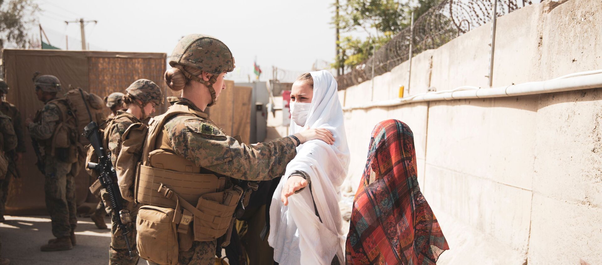A U.S. Marine checks two civilians during processing through an Evacuee Control Checkpoint (ECC) during an evacuation at Hamid Karzai International Airport, Kabul, Afghanistan August 18, 2021. - Sputnik Brasil, 1920, 19.08.2021