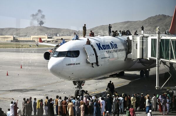 Afegãos sobem ao topo de um avião no aeroporto de Cabul, Afeganistão, 16 de agosto de 2021 - Sputnik Brasil
