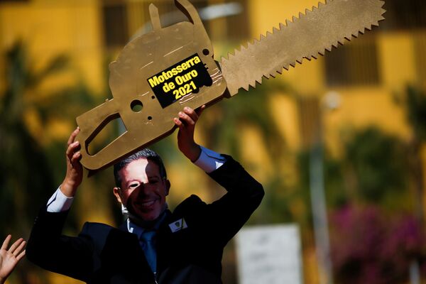 Ativista de Greenpeace retratando Arthur Lira, presidente da Câmara, e segurando uma “serra elétrica” em protesto contra a política ambiental do Congresso, 17 de agosto de 2021 - Sputnik Brasil