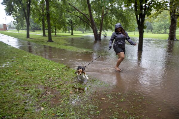 Mulher passeia com cachorro por caminho inundado devido à tempestade tropical Henri em Hartford, Connecticut, EUA, 22 de agosto de 2021 - Sputnik Brasil