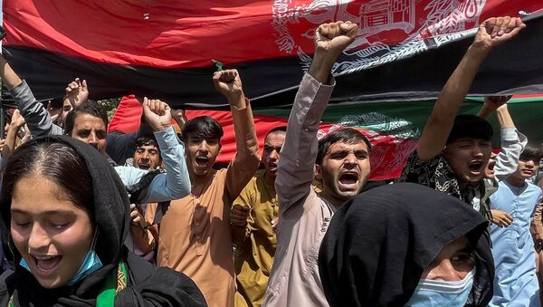 Pessoas carregam bandeira nacional afegã durante protestos no Dia da Independência em Cabul, Afeganistão, 19 de agosto de 2021 - Sputnik Brasil