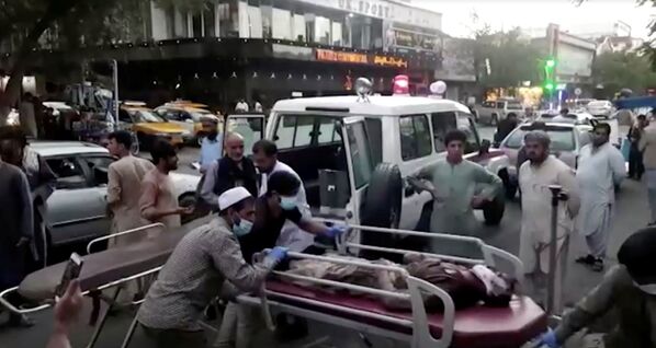 Captura de tela mostra pessoas carregando um ferido para um hospital em Cabul, Afeganistão, 26 de agosto de 2021 - Sputnik Brasil