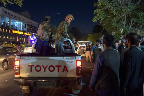 Militantes do Talibã (organização terrorista proibida na Rússia e em vários outros países) em uma caminhonete perto de um hospital, enquanto voluntários trazem feridos para tratamento, Cabul, Afeganistão, 26 de agosto de 2021 - Sputnik Brasil