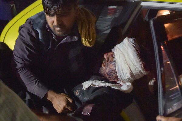 Homem retira um ferido de um carro para tratamento, Cabul, Afeganistão, 26 de agosto de 2021 - Sputnik Brasil