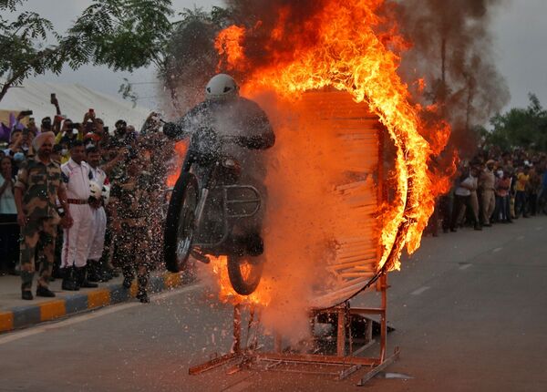 Militar da Força de Segurança de Fronteira da Índia executa acrobacia em sua moto durante um show 
 - Sputnik Brasil