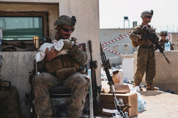 Fuzileiro naval dos EUA segura um bebê nos braços durante evacuação no Aeroporto Internacional de Cabul, Afeganistão
 - Sputnik Brasil