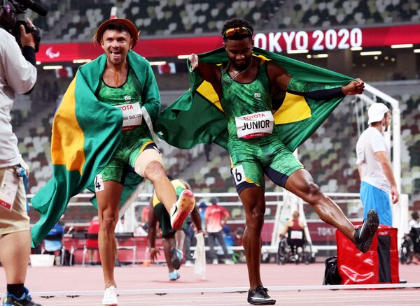 Medalhista paralímpico na prova de 100 m, na classe T47, Petrúcio Ferreira dos Santos, e medalhista de bronze Washington Junior comemoram com as bandeiras do Brasil após a competição
 - Sputnik Brasil