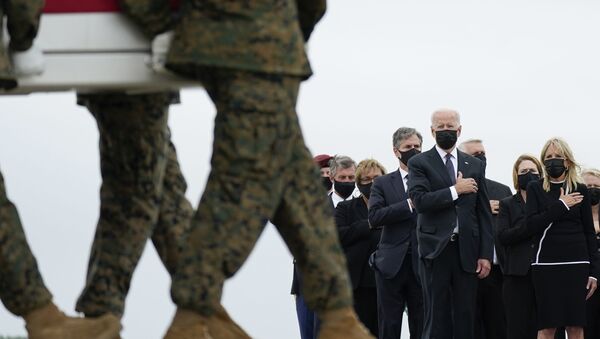 Presidente Joe Biden e primeira-dama Jill Biden olham para um caixão com os restos de um soldado americano transportado do Afeganistão, base aérea de Dover, EUA, 29 de agosto de 2021 - Sputnik Brasil