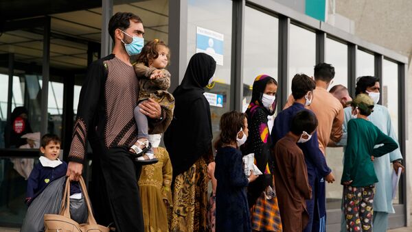 Refugiados afegãos caminham até um ônibus que os leva a um centro de processamento na chegada ao Aeroporto Internacional de Dulles em Dulles, Virgínia, EUA, 29 de agosto de 2021 - Sputnik Brasil