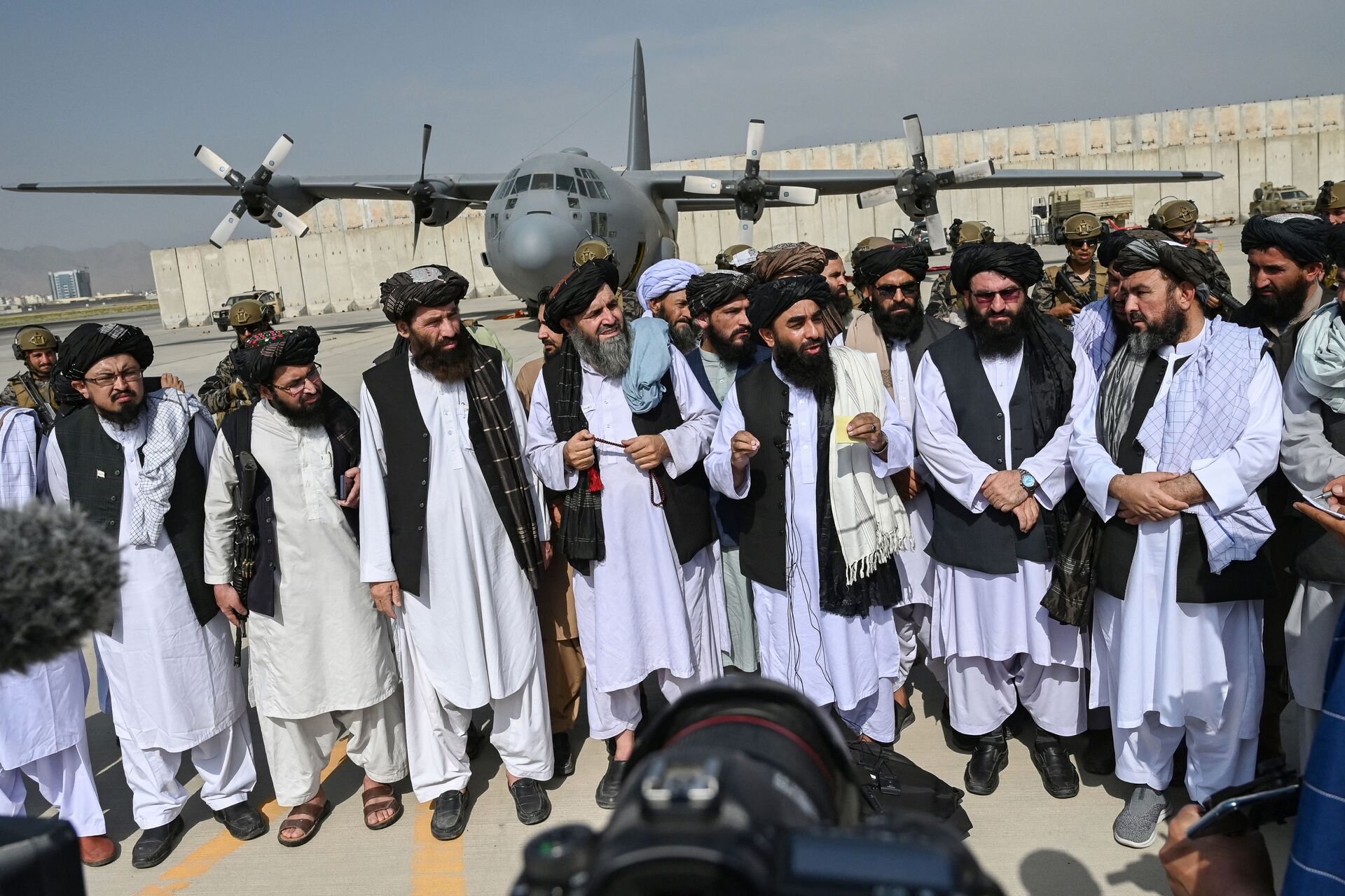 Porta-voz do Talibã, Zabihullah Mujahid (no centro com xaile), faz anúncio no aeroporto de Cabul após a saída das tropas americanas, 31 de agosto de 2021 - Sputnik Brasil, 1920, 09.11.2021