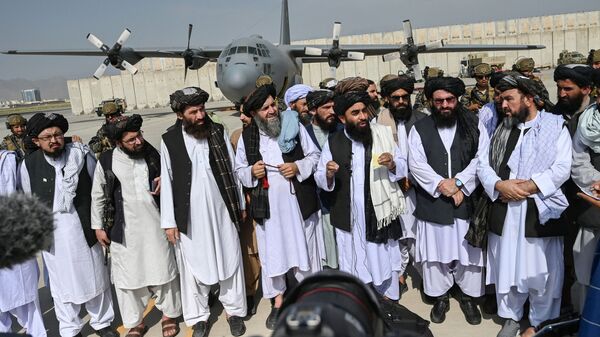 Porta-voz do Talibã, Zabihullah Mujahid (no centro com xaile), faz anúncio no aeroporto de Cabul após a saída das tropas americanas, 31 de agosto de 2021 - Sputnik Brasil