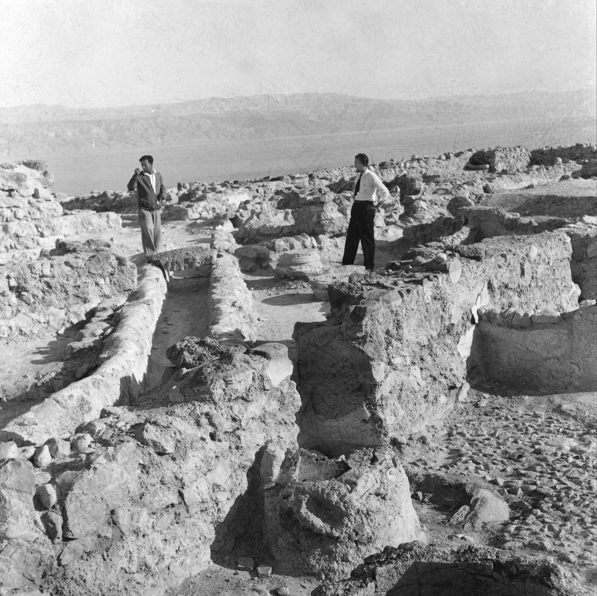 Dois homens contemplam as ruínas de Qumran, descobertas em 1947, na margem noroeste do mar Morto, na Jordânia, em 14 de janeiro de 1957 - Sputnik Brasil, 1920, 09.11.2021