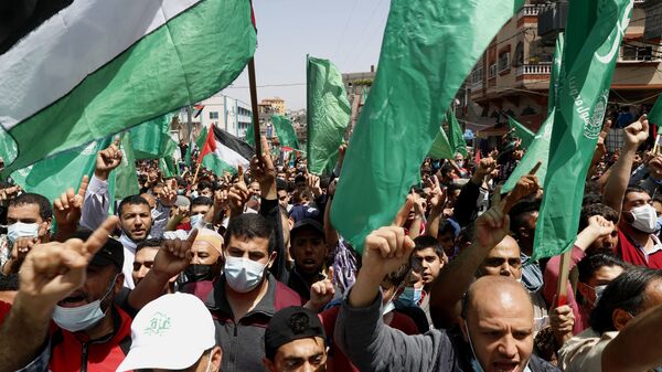 Apoiadores do Hamas agitam bandeiras durante um comício contra a decisão do presidente palestino, Mahmoud Abbas, de adiar as eleições palestinas, em Jebaliya. Faixa de Gaza, 30 de abril de 2021 - Sputnik Brasil