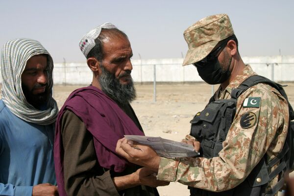 Soldado paquistanês verifica documentos das pessoas chegadas do Afeganistão, cidade fronteiriça de Chaman, Paquistão, 27 de agosto de 2021. - Sputnik Brasil