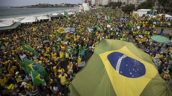 Apoiadores do presidente Jair Bolsonaro (sem partido) carregam a bandeira do Brasil na praia de Copacabana, no Rio de Janeiro, em 7 de setembro de 2021 - Sputnik Brasil