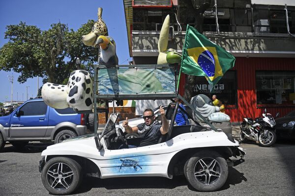 Homem celebra Dia da Independência do Brasil enquanto conduz seu carro, perto da praia de Copacabana, em 7 de setembro de 2021. - Sputnik Brasil
