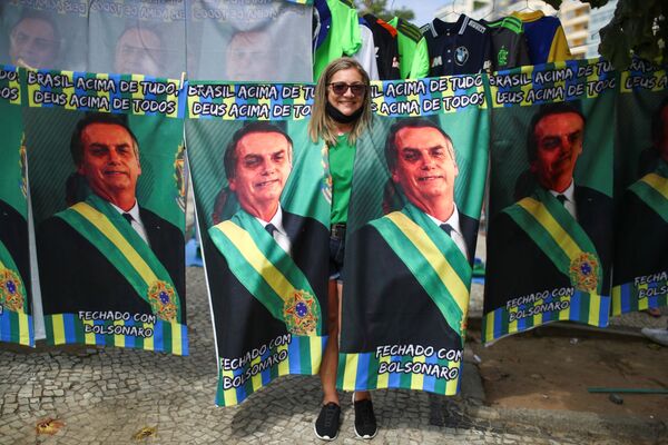 Mulher apoiadora de Bolsonaro posa para foto no meio de cartazes com retrato do presidente brasileiro, em 7 de setembro de 2021. - Sputnik Brasil