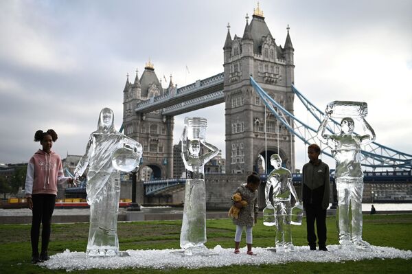 Crianças pousando perto de estátuas de gelo em Londres, no Reino Unido, refletindo a fragilidade da água ante as alterações climáticas, em 15 de setembro de 2021. - Sputnik Brasil