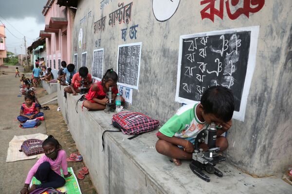 Crianças sem acesso à Internet utilizam miscroscópios em aula ao ar livre na aldeia de Joba Attpara, no estado indiano de Bengala ocidental, em 13 de setembro de 2021. - Sputnik Brasil