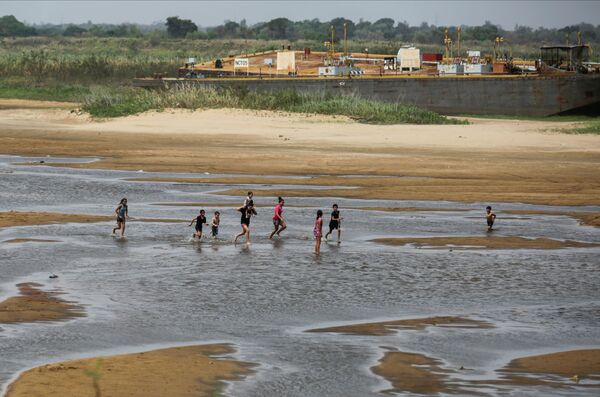 Crianças brincam nas margens do rio Paraguai, em Lambare, na República do Paraguai, uma vez que a falta de chuva no Brasil, onde o rio nasce, fez baixar o nível da água, em 13 de setembro de 2021. - Sputnik Brasil