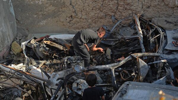 Parente de Zemari Ahmadi inspeciona os destroços do veículo atingido por ataque de drone dos EUA em Cabul, em 18 de setembro de 2021 - Sputnik Brasil