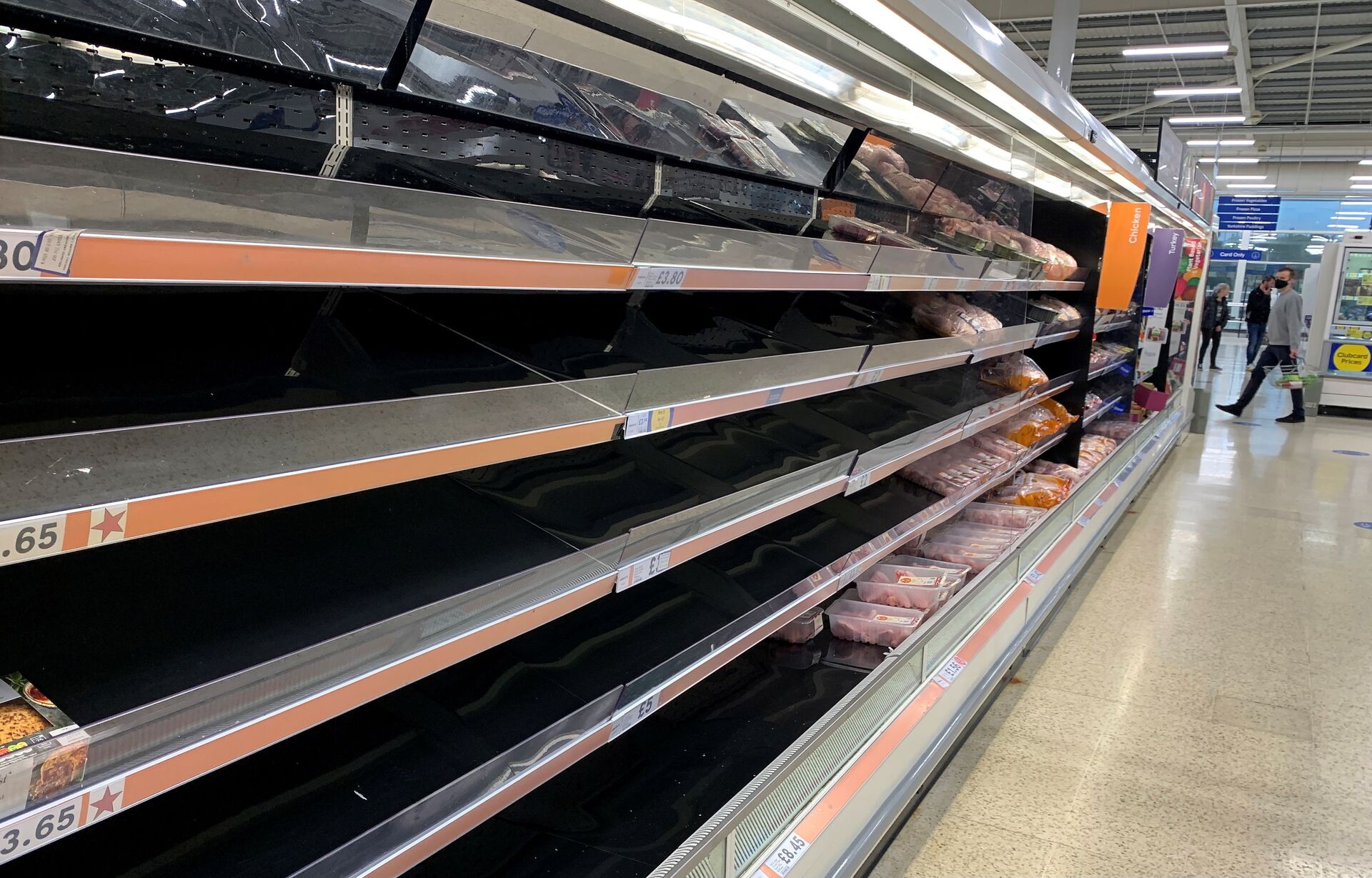 Consumidor passa por prateleiras vazias no corredor de carnes de um supermercado em Manchester, Reino Unido, em 21 de setembro de 2021 - Sputnik Brasil, 1920, 09.11.2021