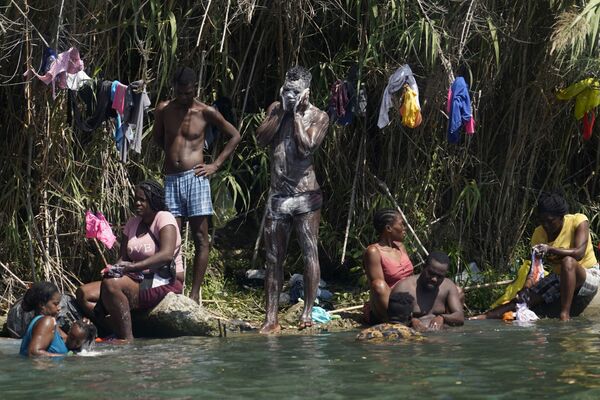 Refugiados haitianos se lavando nas margens do rio Grande durante travessia do México para os EUA, em 18 de setembro de 2021. - Sputnik Brasil
