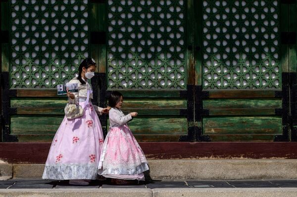 Visitantes usando roupas tradicionais no Palácio Gyeongbokgung em Seul, capital sul-coreana, em 20 de setembro de 2021. - Sputnik Brasil