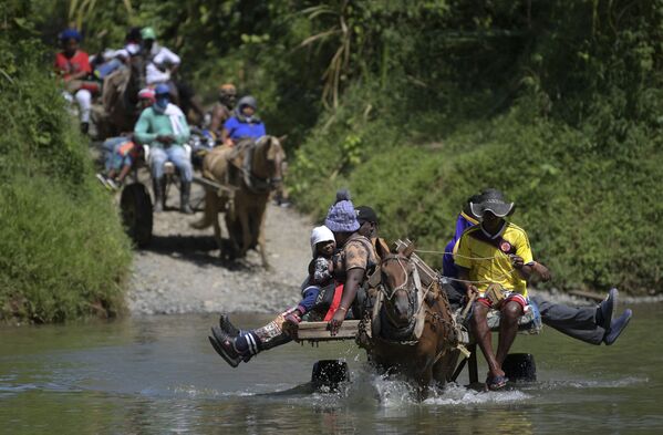  Migrantes haitianos cruzam um rio a caminho da fronteira com o Panamá em Acandí, Colômbia, 25 de setembro de 2021. - Sputnik Brasil