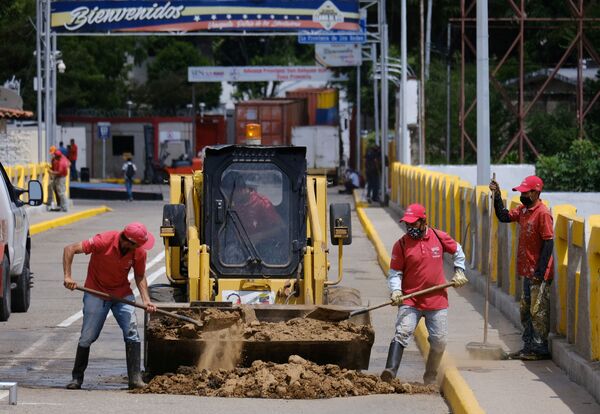 Operários tapam um buraco onde havia um contêiner bloqueando a passagem na Ponte Internacional Simón Bolívar, 4 de outubro de 2021. - Sputnik Brasil