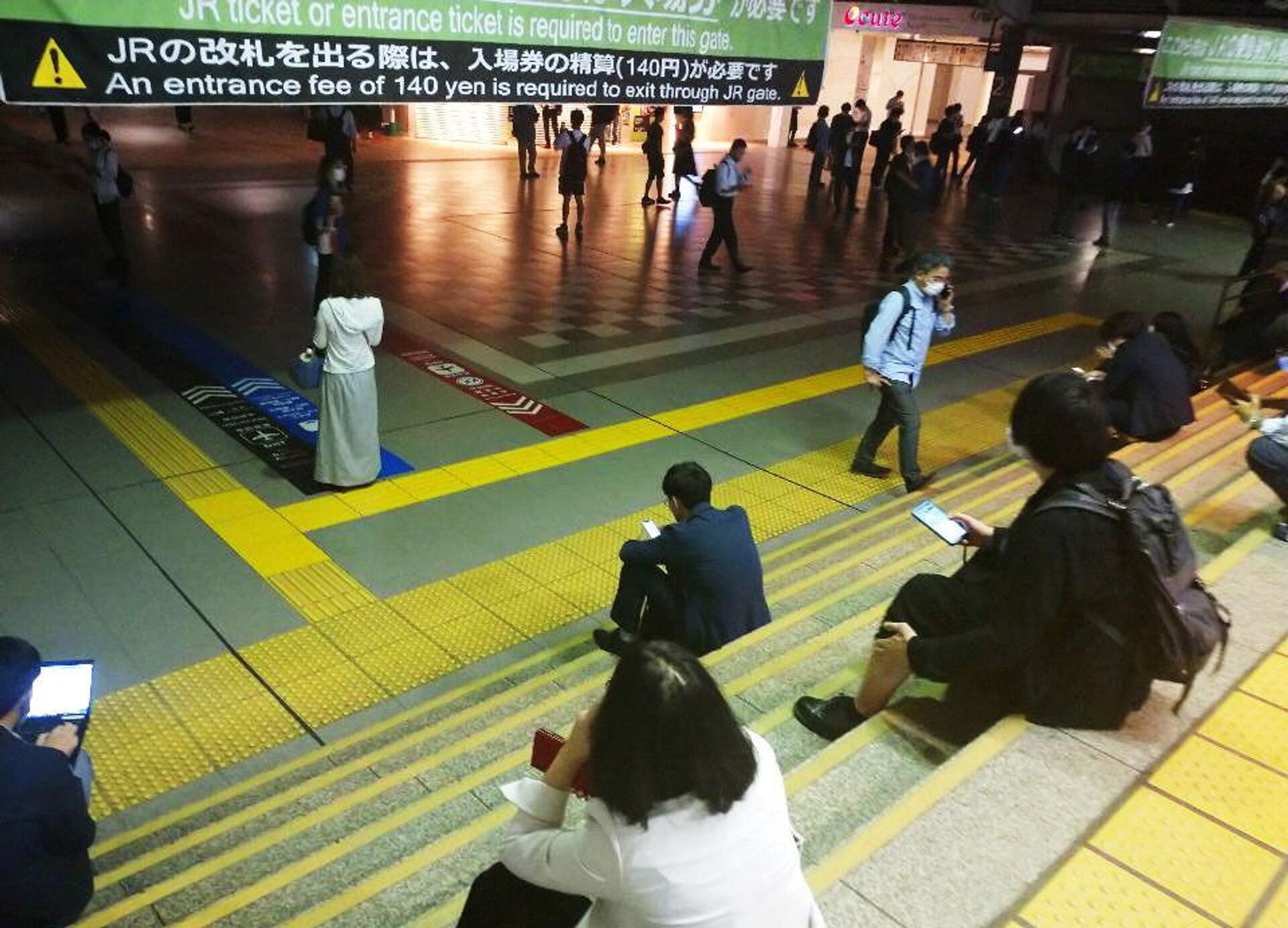 Passageiros esperam sentados nas escadas enquanto os serviços de trem não voltam após terremoto em Tóquio, Japão, em 7 de outubro de 2021 - Sputnik Brasil, 1920, 09.11.2021