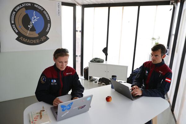 Astronauta alemã Anika Mehlis e seu colega austríaco Robert Wild analisam dados em seus computadores portáteis antes de uma missão de treinamento em Israel, em 10 de outubro de 2021. - Sputnik Brasil