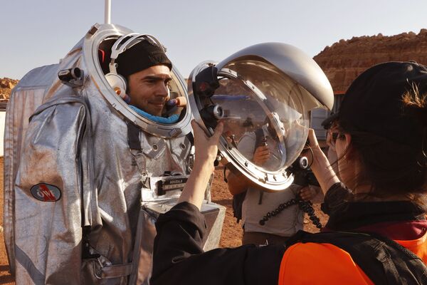 Assistentes técnicos ajudam a garantir que seu traje espacial está bem colocado antes de uma missão de treinamento, em Israel, em 10 de outubro de 2021. - Sputnik Brasil