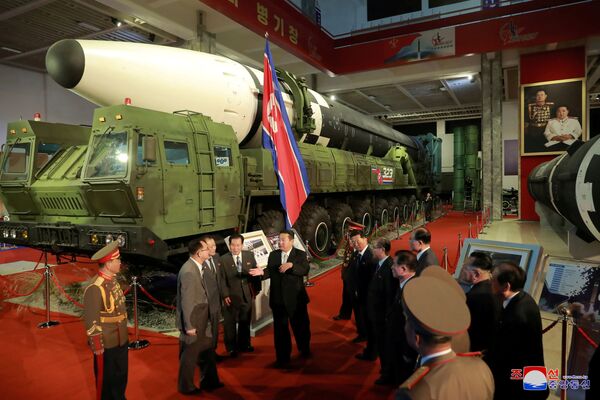 Líder norte-coreano, Kim Jong-un, conversa com oficiais ao lado de armas e veículos militares na exposição Autodefesa-2021, Pyongyang, Coreia do Norte, foto divulgada em 12 de outubro de 2021. - Sputnik Brasil