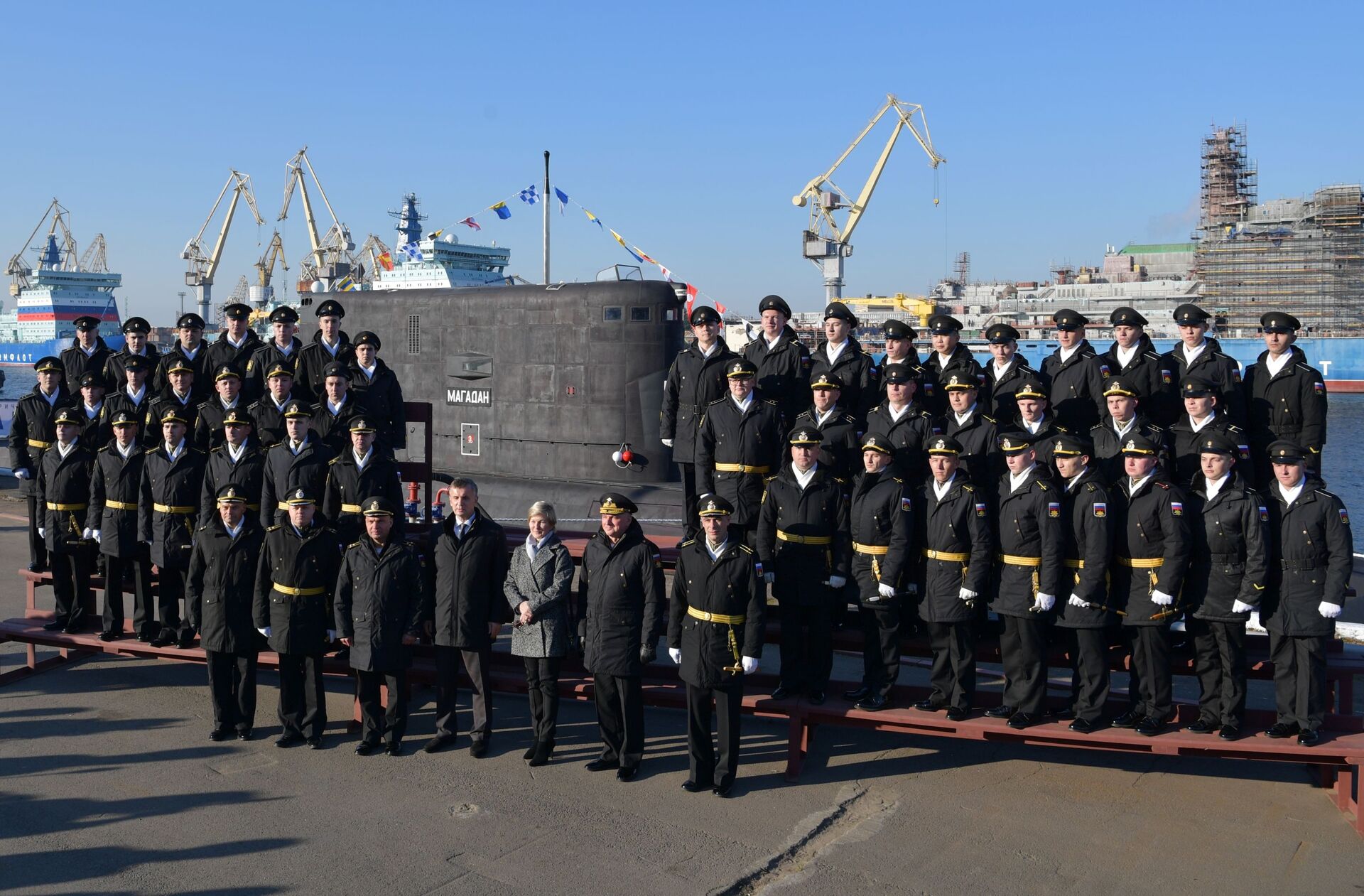 Diretor-geral dos Estaleiros do Almirantado, Aleksandr Buzakov (primeira fila, ao centro), com marinheiros russos na cerimônia solene de hasteamento de bandeira no novo submarino Magadan, 12 de outubro de 2021 - Sputnik Brasil, 1920, 09.11.2021