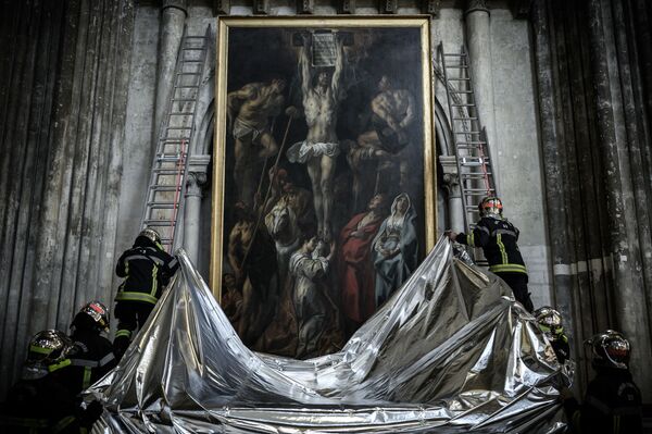 Bombeiros franceses protegem uma pintura com um cobertor à prova de fogo durante uma simulação de incêndio que visa preservar obras de arte exibidas na catedral de Saint-André em Bordeaux. - Sputnik Brasil