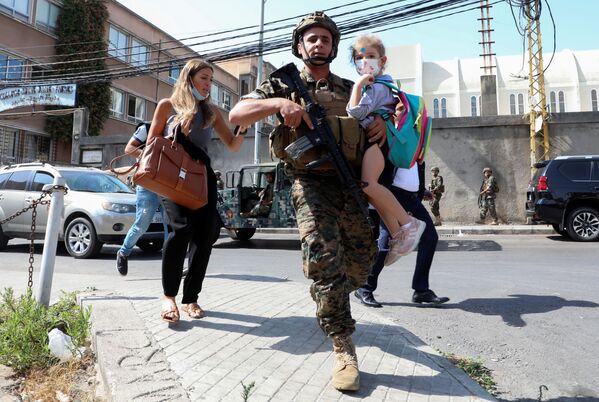 Soldado carrega uma menina enquanto civis fogem do tiroteio em Beirute, Líbano. - Sputnik Brasil