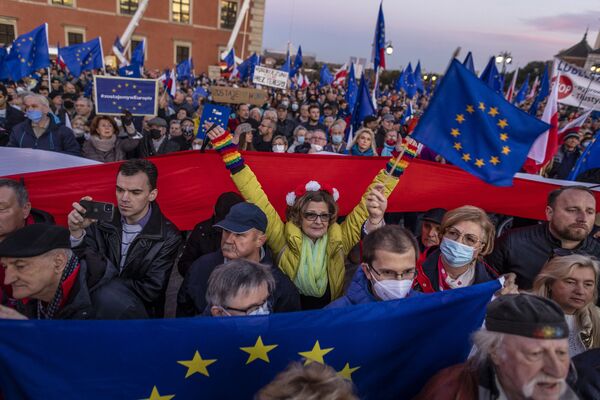Poloneses agitam bandeiras da União Europeia em uma manifestação em Varsóvia. - Sputnik Brasil
