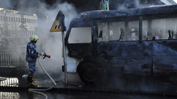 Foto divulgada pela agência de notícias SANA mostra bombeiro apagando fogo de ônibus atingido por explosão em Damasco, Síria, 20 de outubro de 2021 - Sputnik Brasil