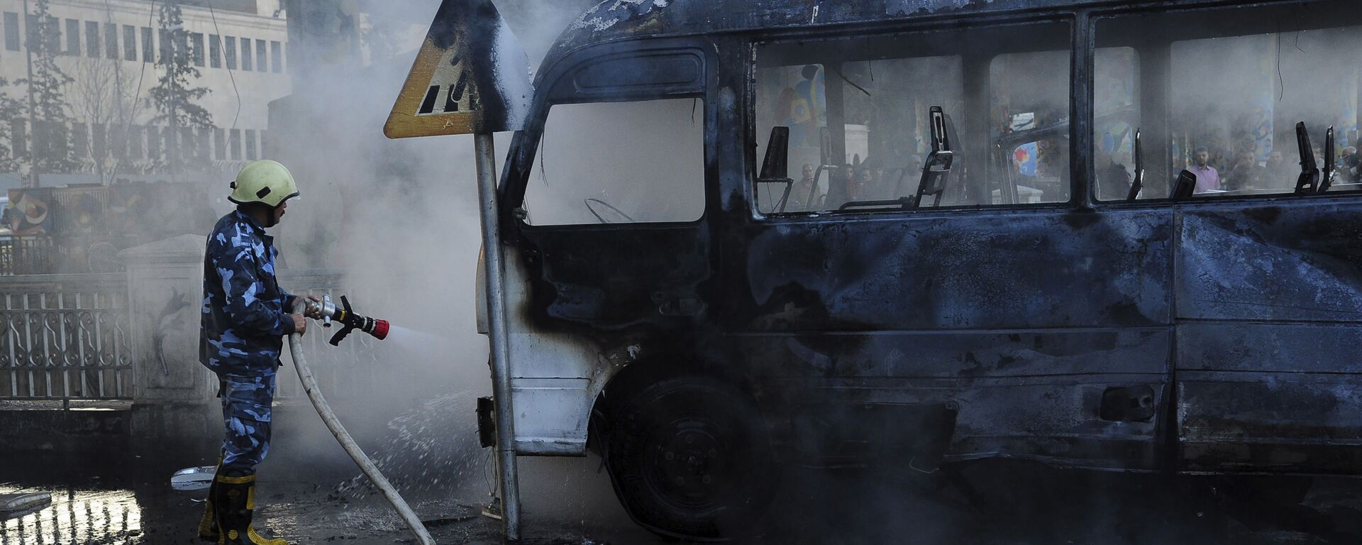 Foto divulgada pela agência de notícias SANA mostra bombeiro apagando fogo de ônibus atingido por explosão em Damasco, Síria, 20 de outubro de 2021 - Sputnik Brasil, 1920, 30.12.2022