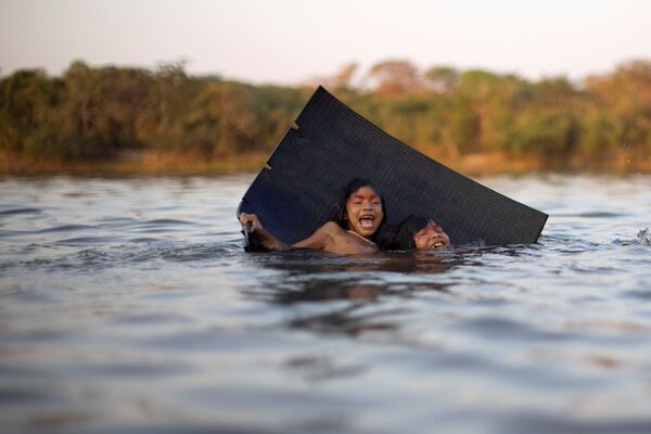 Crianças yawalapiti brincam no rio Tuatuari durante o ritual fúnebre Kuarup em homenagem à memória do cacique Aritana. - Sputnik Brasil