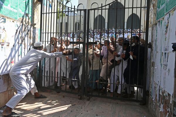 Manifestantes tentam quebrar portão trancado de mesquita nacional durante um protesto após as orações de sexta-feira em Daca, em 15 de outubro de 2021. - Sputnik Brasil