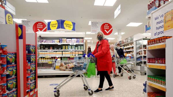 A woman wearing a face mask pushes a shopping cart at a Tesco supermarket in Hatfield, Britain October 6, 2020. - Sputnik Brasil