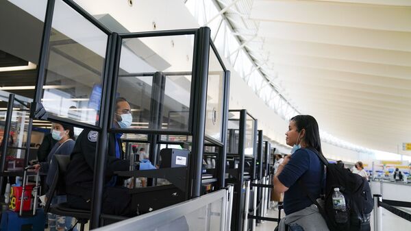 Pessoal da Administração de Segurança de Transporte observam protocolos de prevenção da transmissão da COVID-19 no Aeroporto Internacional John F. Kennedy, Nova York - Sputnik Brasil