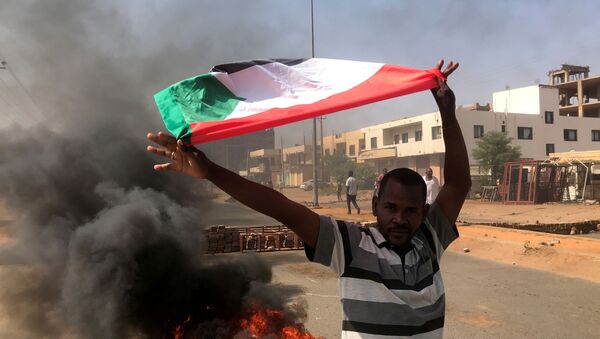 Um manifestante agita uma bandeira durante o que o ministério da informação chama de golpe militar em Cartum, Sudão, em 25 de outubro de 2021 - Sputnik Brasil