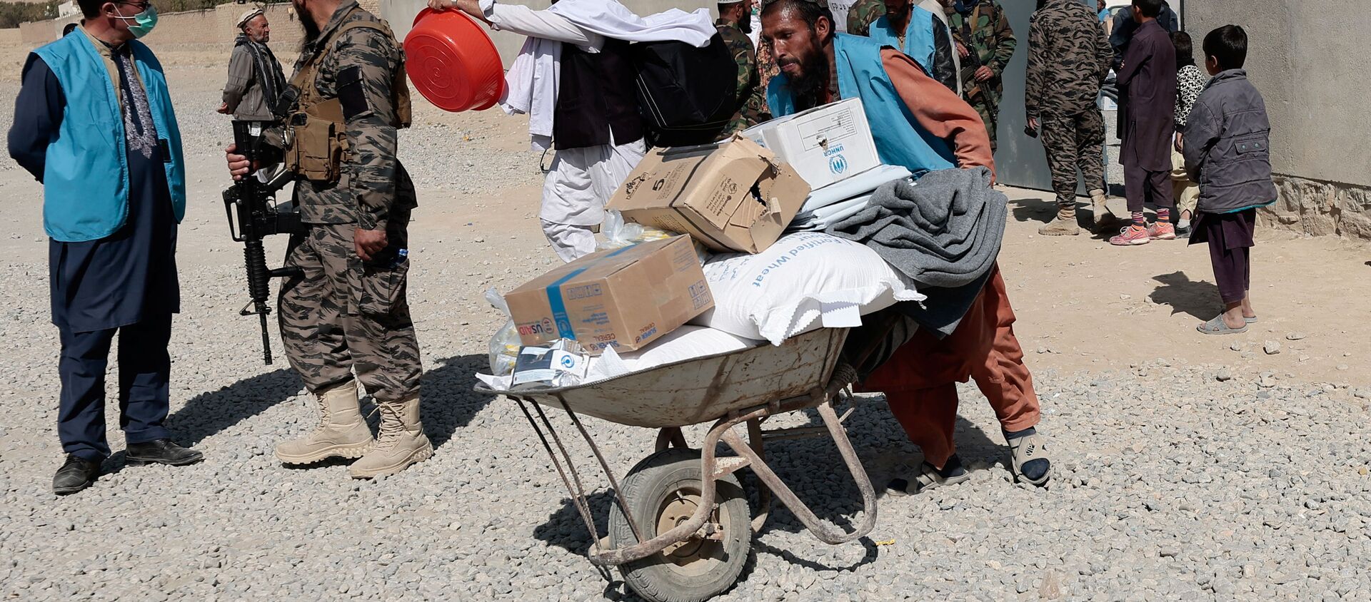 Trabalhador do Alto-comissariado das Nações Unidas para os Refugiados empurra carrinho com provisões para centro de distribuição de ajuda alimentar em Cabul, Afeganistão, 28 de outubro de 2021 - Sputnik Brasil, 1920, 29.10.2021
