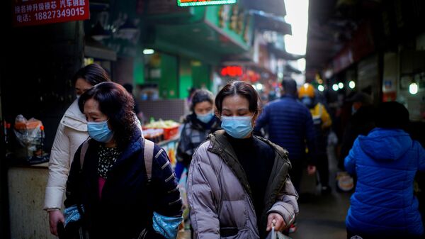 Pessoas usando máscaras andam em um mercado de rua nos primeiros meses do surto da doença coronavírus (COVID-19) em Wuhan, província de Hubei, China, 8 de fevereiro de 2021 - Sputnik Brasil
