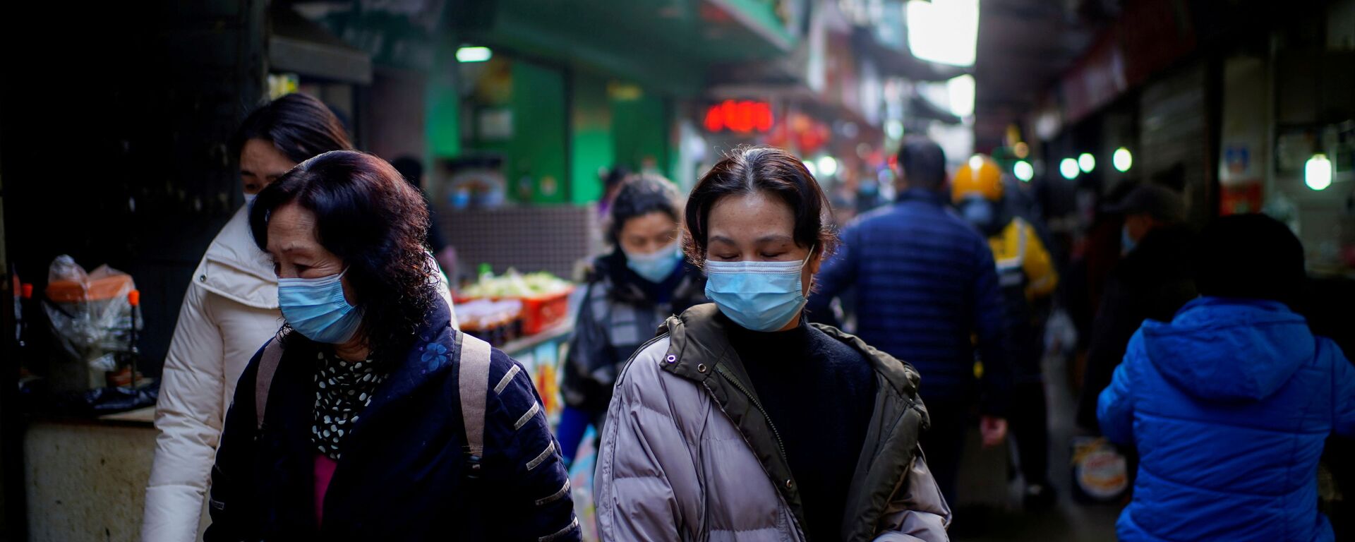 Pessoas usando máscaras andam em um mercado de rua nos primeiros meses do surto da doença coronavírus (COVID-19) em Wuhan, província de Hubei, China, 8 de fevereiro de 2021 - Sputnik Brasil, 1920, 29.10.2021